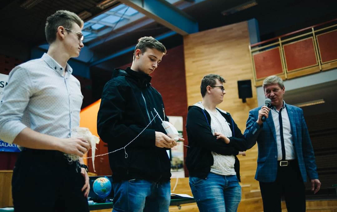4 people, one speaking with a microphone
